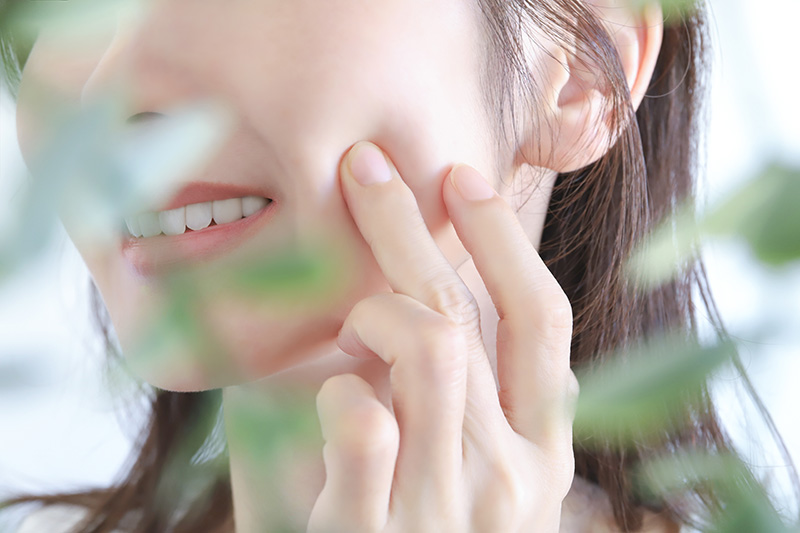 頬を触る女性
